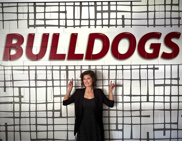 picture of woman pointing at bulldog sign 