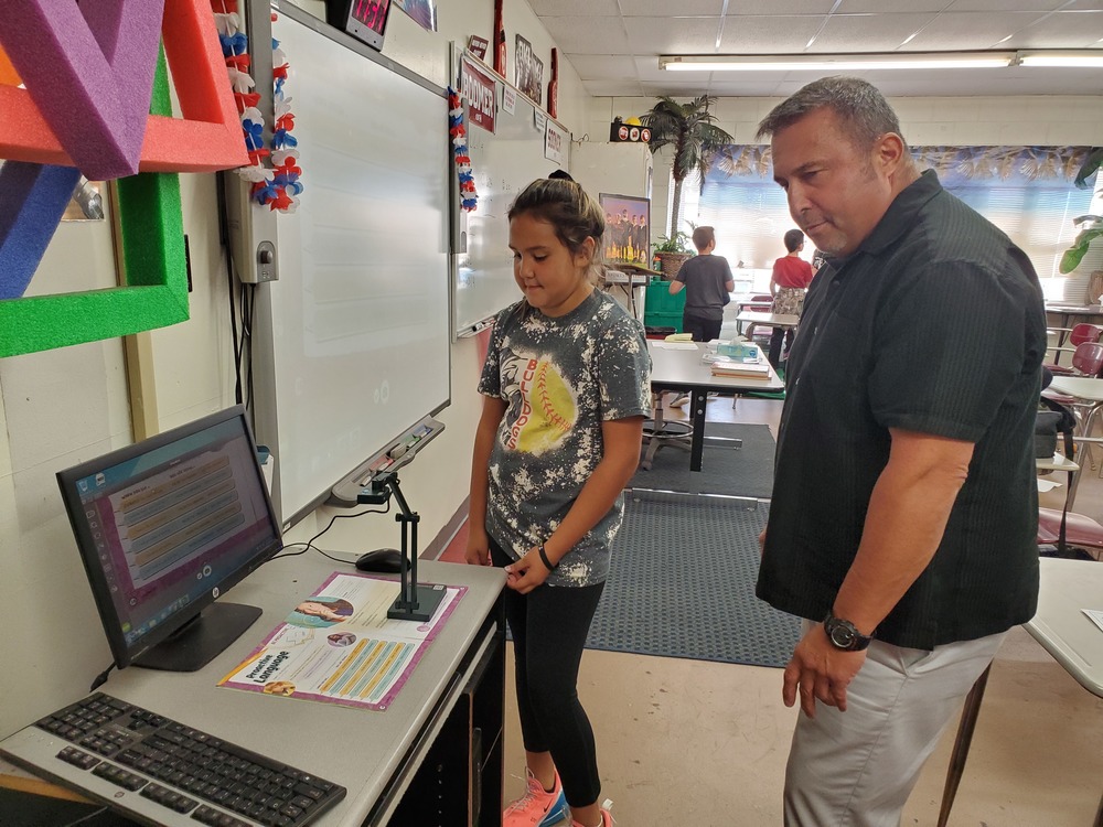 CIS Coach Brown shows Kenzi Fourkiller how his new document camera works.